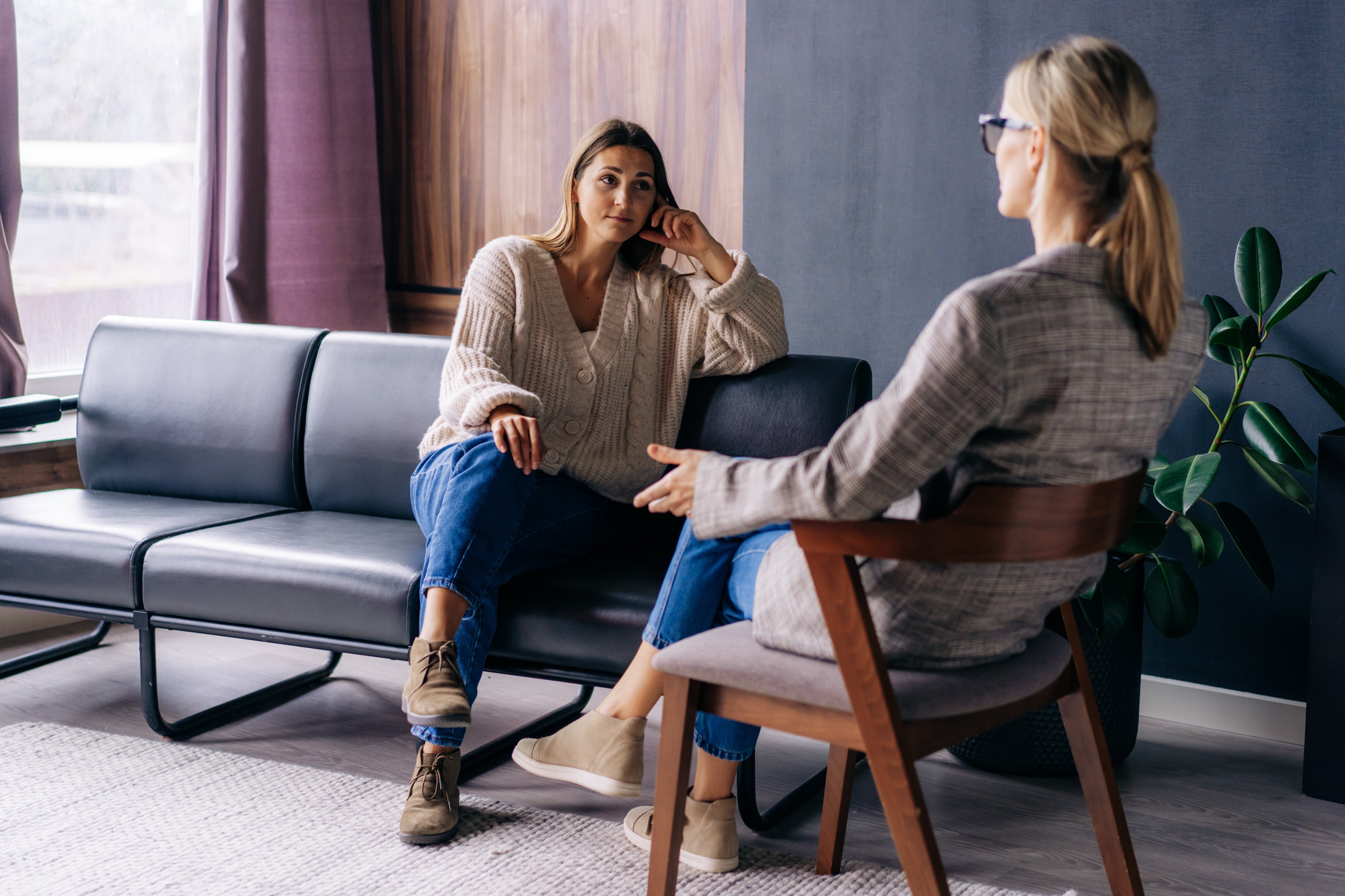 Woman talks to female therapist in comfortable office