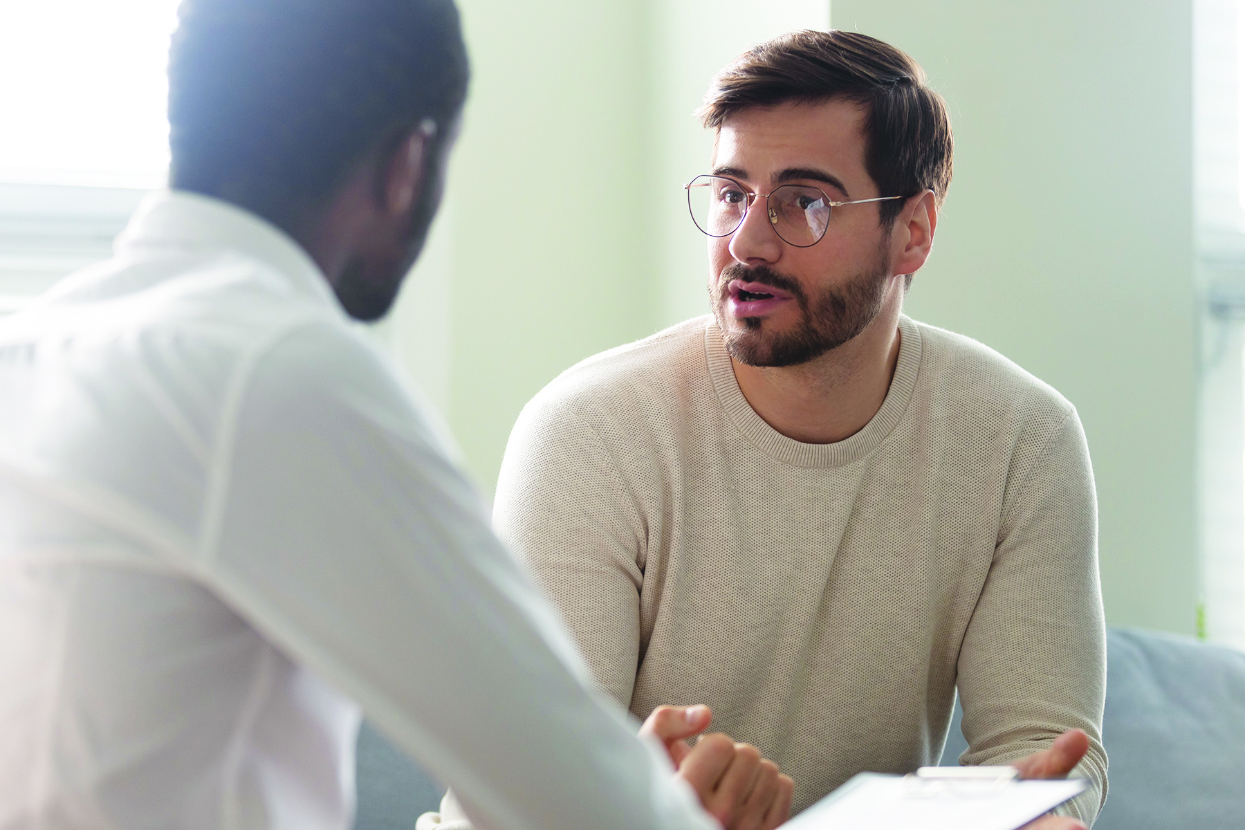 two men speaking together in a therapy session